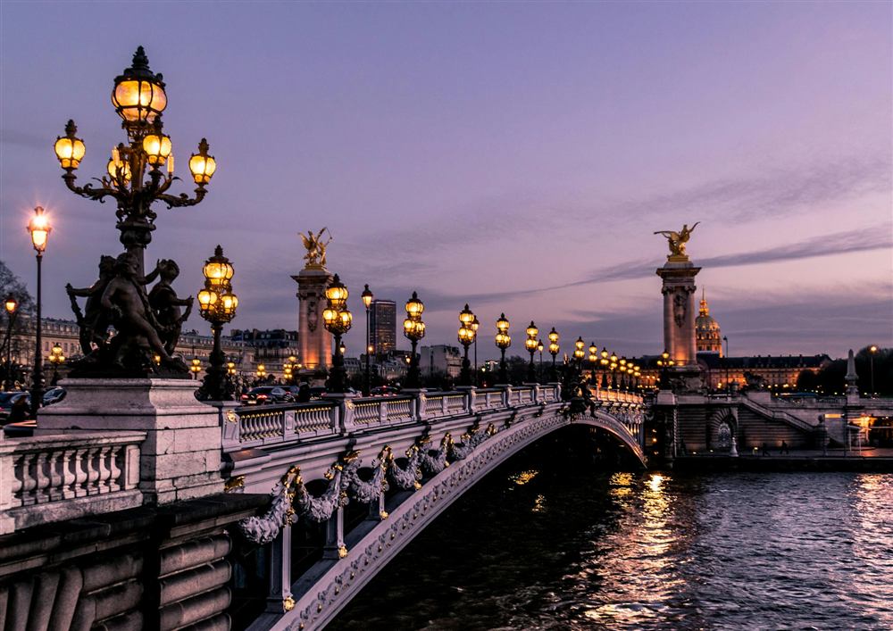 Ornate lamps on a Paris bridge at dusk