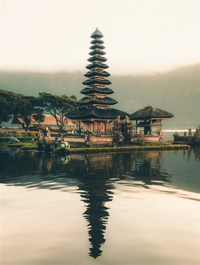 Balinese temple reflected in calm lake water