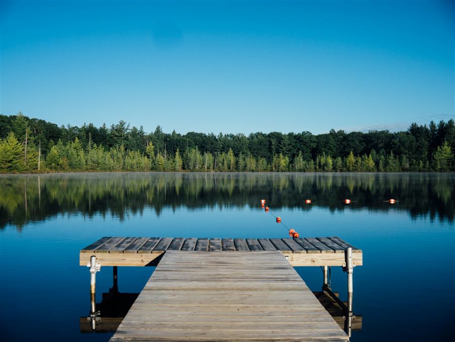 Wooden jetty extending into a calm lake at dawn
