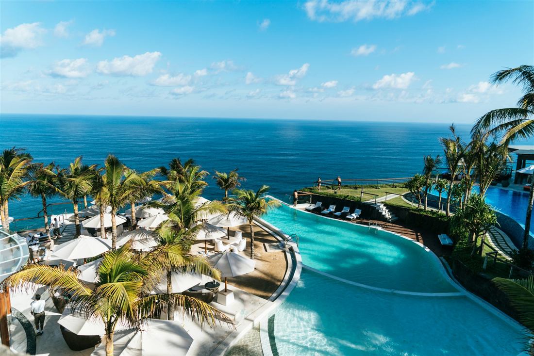 Infinity pool and palms above the Maldivian ocean